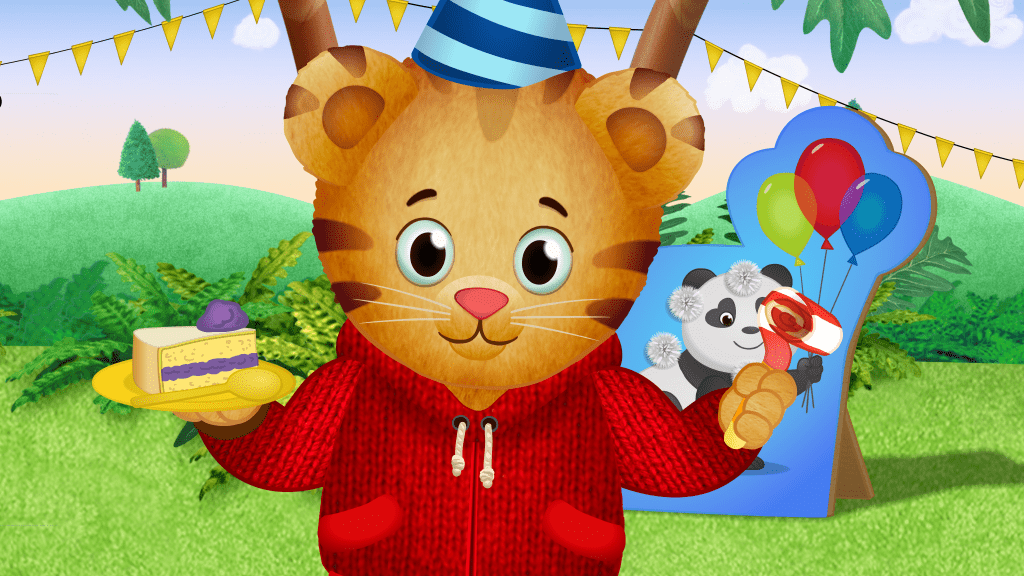 Daniel Tiger holding cake, wearing a party hat in front of a green field backdrop