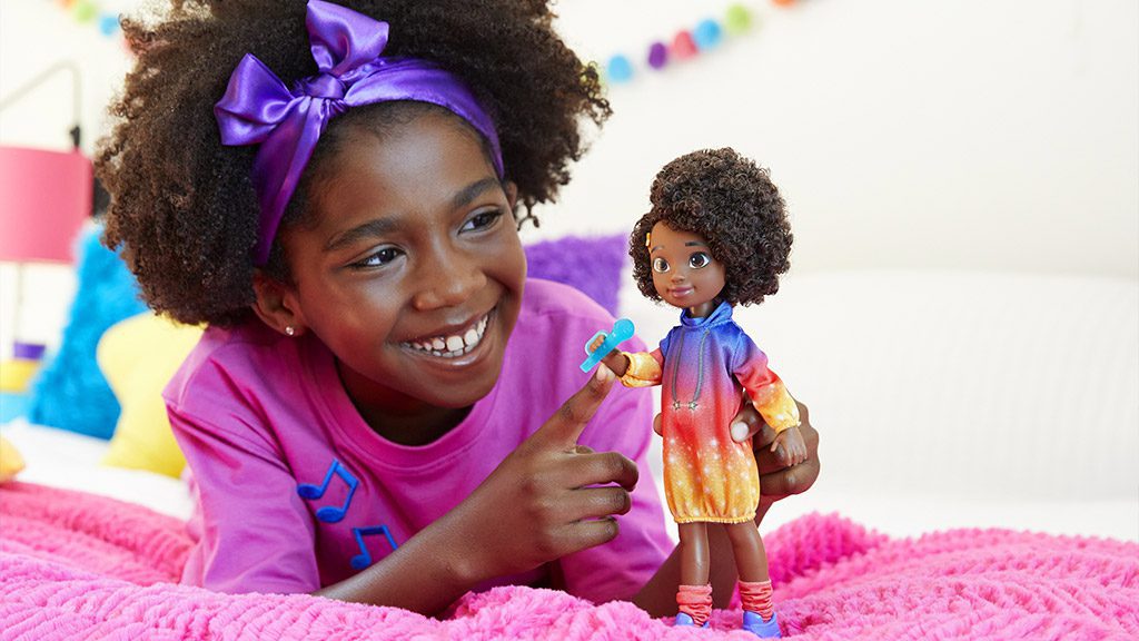 A young with a purple ribbon in her hair, playing with the Karma Grant doll