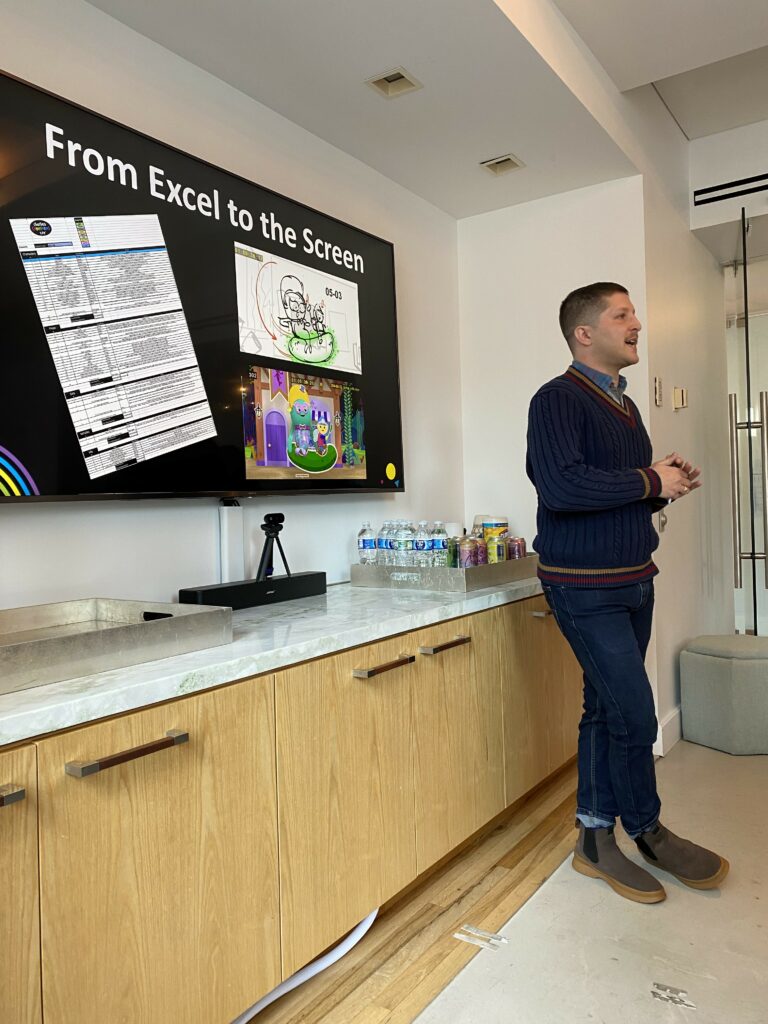 Jamie Cohen presents to using a large LCD monitor behind him, in the 9 Story Studio in New York City.