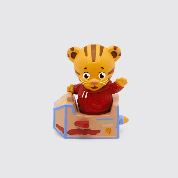 A little tiger figurine in a red sweater and a cardboard rocket
