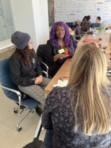 Two respectability fellows work with Danielle a producer at 9 Story Media Group. All are seated at a table in the board room of 9 Story's New York Studio.